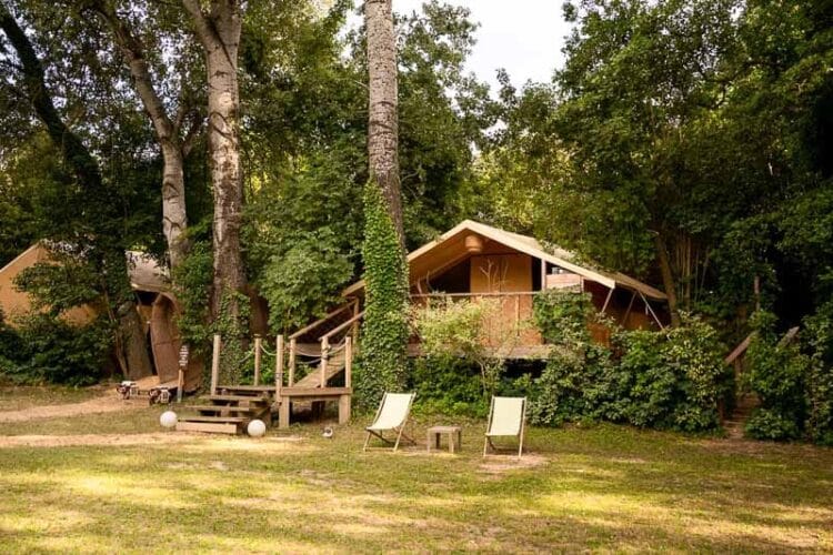 Emplacement du lodge Clairière avec son petit pont et 2 chiliennes avec leur table basse