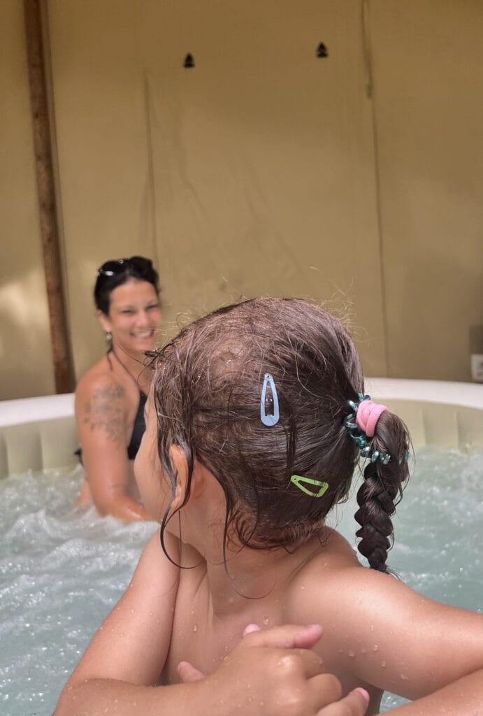 une petite fille qui est retournée pour regarder sa maman dans un spa