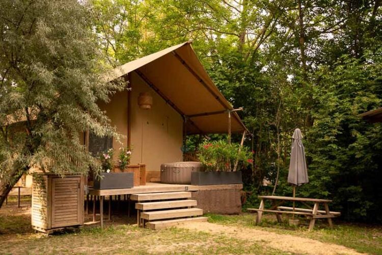 Lodge Rivière avec le spa sur la terrasse et la table de jardin sur l'emplacement