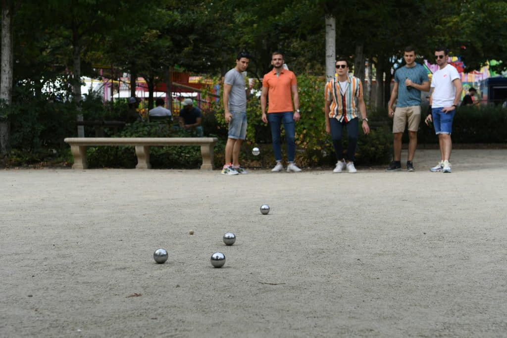 un groupe de 5 hommmes jouant à la pétanque